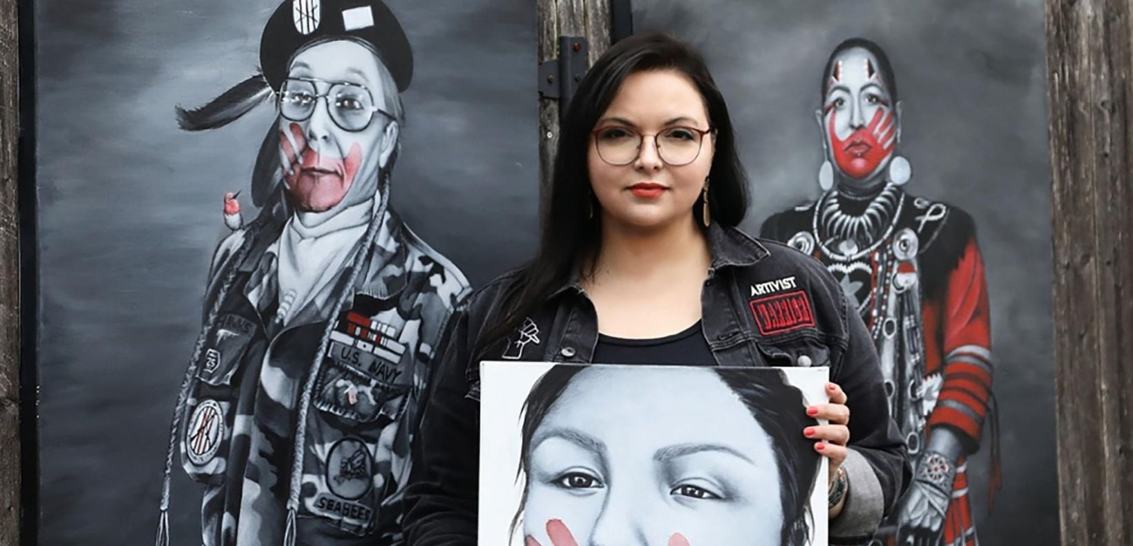LaFond poses with one of the MMIWG Portraits in Red paintings.